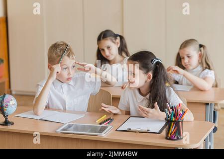 Girl talking with boy during lesson Stock Photo