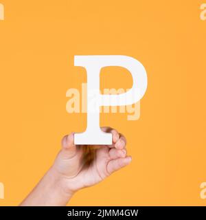 Woman s hand holding white letter p Stock Photo