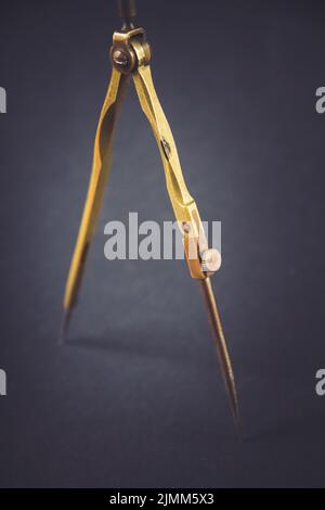 Old vintage pair of compasses on dark background Stock Photo