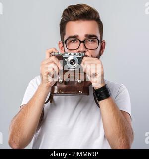 Photographer man with retro camera in studio Stock Photo