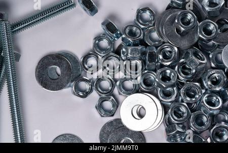 Metal nuts and washers for bolts isolated on white. Nuts for bolts close-up. Metal objects in close-up. Stock Photo