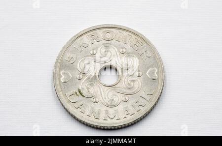 Danish krone coinscloseup on white. The krone is the official currency of Denmark, Greenland, and the Faroe Islands, introduced on 1 January 1875. Stock Photo