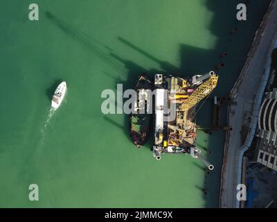 Floating crane dredging barges working on the construction of a marina. Aerial top view Stock Photo