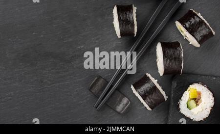 Set of sushi and maki rolls with branch of white flowers and teapot ...