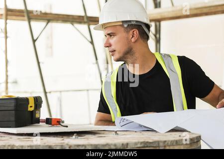 Worker is checking blueprints during his work on a construction site Stock Photo