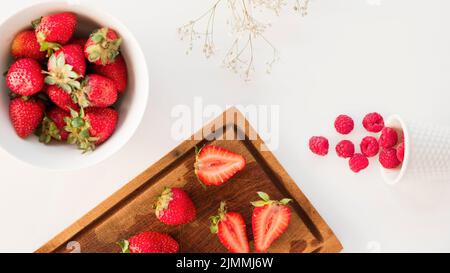 Overhead view strawberries raspberries with gypsophila flower isolated white background Stock Photo