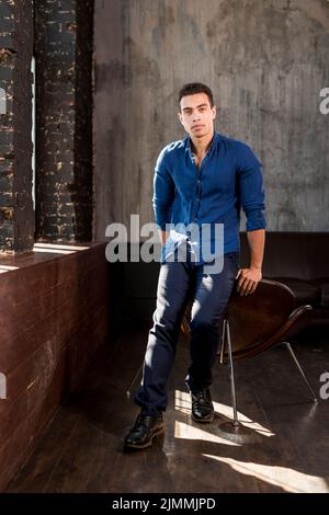 Portrait handsome young man leaning chair room Stock Photo