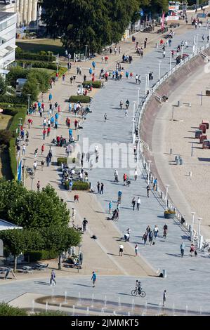 07 August 2022, Schleswig-Holstein, Lübeck: Participants of the Holstentorturnier and strollers can be seen on the beach promenade. The Holsten Gate Tournament is considered the largest German boules tournament. Photo: Georg Wendt/dpa Stock Photo