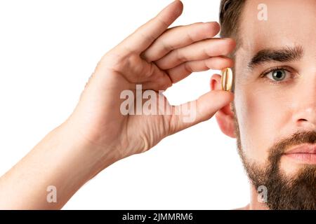 Man holding capsule with a fish or krill oil source of fatty acids such as DHA and EPA Stock Photo