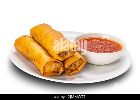 Pile of deep fried Spring Rolls with chili sauce in white ceramic dish on white background. Stock Photo