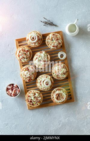 mini portions of flammekueche, or tarte flambee, french and german speciality, on the wooden cooling grid, top view Stock Photo