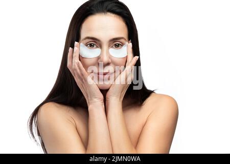 Middle aged woman with applied sheet patches under her eyes. Stock Photo