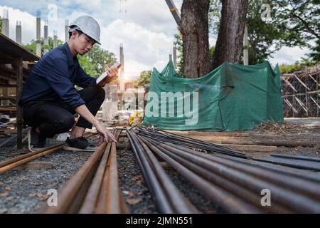 Engineers are checking the quality of deformed bars at the outdoors construction site Stock Photo