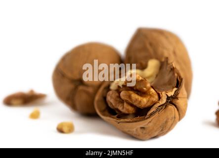 Halves and a bunch of walnuts on a white background close up Stock Photo