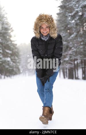 Young and cheerful woman enjoying walking during beautiful winter day Stock Photo