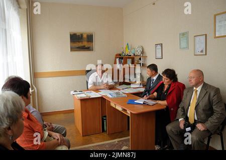 Man principal holding a meeting in his office, teachers listening to, typical Ukrainian secondary school. August 13, 2019. Chernigiv, Ukraine Stock Photo