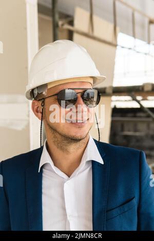 Architect or businessman wearing formal suit and hard hat on a construction site Stock Photo