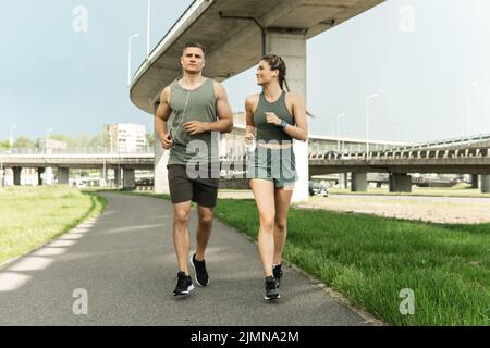 Sportive couple during jogging workout on city street Stock Photo