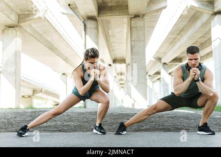 Athletic couple warming up during street workout Stock Photo