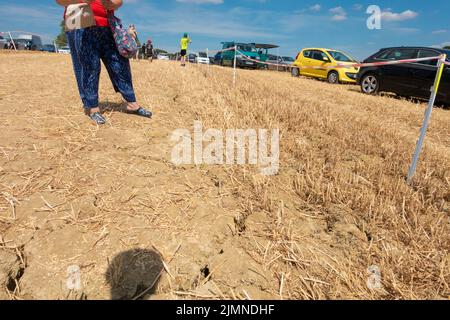 Woodchurch, Kent, UK. 7th Aug, 2022. UK Weather: Harvested fields used for parking in Woodchurch hosting the Weald of Kent Steam Rally show deep cracks in the fields through lack of rain water as the drought continues in the South East. Dry cracked earth. Photo Credit: Paul Lawrenson/Alamy Live News Stock Photo
