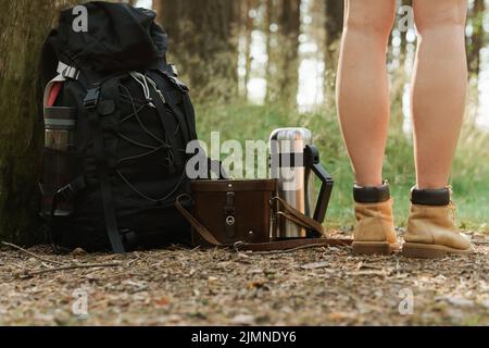 Female legs and hiker's backpack on the ground Stock Photo