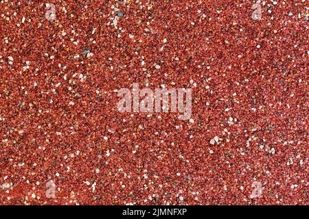 Red stones background. Textured surface covered with small stones. Stock Photo