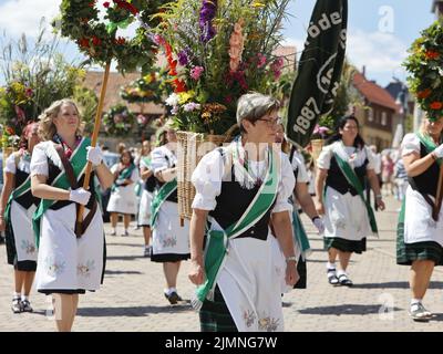 07 August 2022, Saxony-Anhalt, Hüttenrode: Participants of the 'Grasedanz' pageant parade through the village. The Grasekönigin has been elected in Hüttenrode every year since 1885. The custom festival, which focuses on women, is celebrated annually on the first weekend in August. Photo: Matthias Bein/dpa Stock Photo