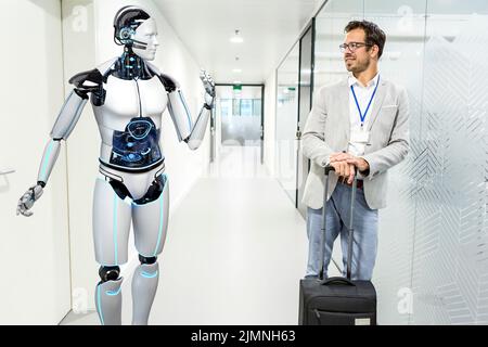 Humanoid robot assists company visitors Stock Photo