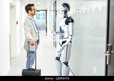 Humanoid robot assists company visitors Stock Photo