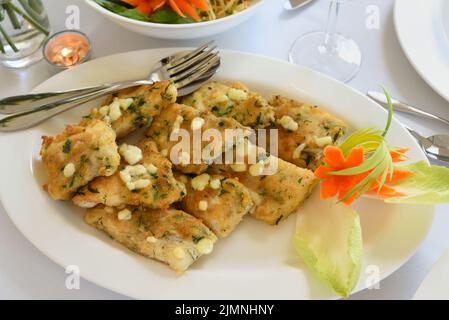 Fried cod fillets in herb crumble on a plate Stock Photo