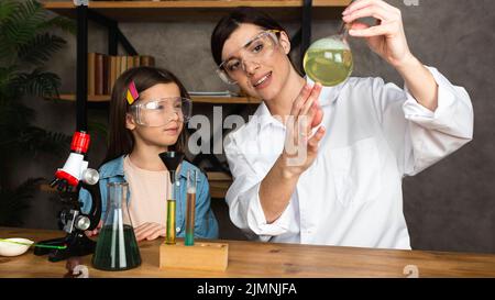 Girl teacher doing science experiments with microscope Stock Photo