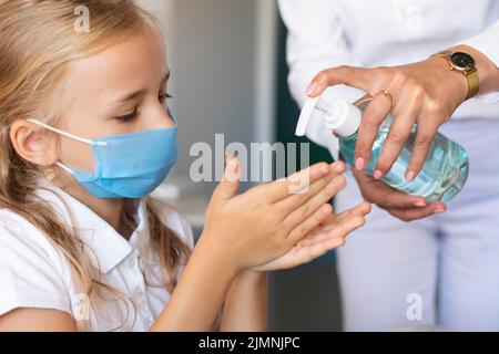 Little girl disinfecting her hands Stock Photo