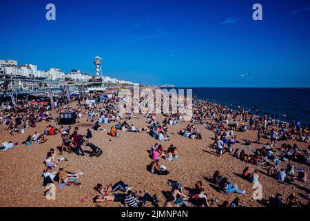 Brighton, UK. 6th August, 2022. People enjoy the sunshine on Brighton beach on the occasion of the 30th anniversary Brighton & Hove Pride LGBTQ+ Community Parade. Brighton & Hove Pride is intended to celebrate, and promote respect for, diversity and inclusion within the local community as well as to support local charities and causes through fundraising. Credit: Mark Kerrison/Alamy Live News Stock Photo