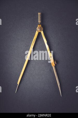 Old vintage pair of compasses on dark background Stock Photo