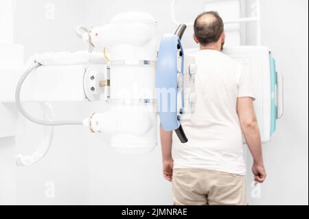 Man in x-ray room having medical scan examination in a modern hospital. Stock Photo