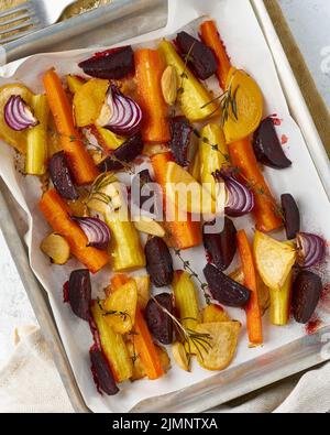 Colorful roasted vegetables on tray with parchment. Mix of carrots, beets, turnips Stock Photo
