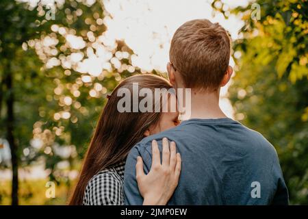 Girl put her head on his shoulder, love in the park, teen couple Stock Photo