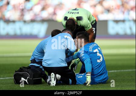 Manchester City goalkeeper Ederson (right) receives treatment after sustaining an injury during the Premier League match at the London Stadium. Picture date: Sunday August 7, 2022. Stock Photo