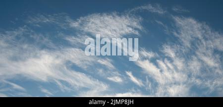 Wispy sweeping clouds across a blue sky Stock Photo