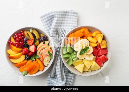 Bowls of healthy fresh fruit salads on white background, top view Stock Photo