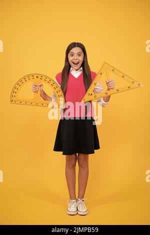 surprised teen girl study math with protractor and triangle measuring size, back to school Stock Photo