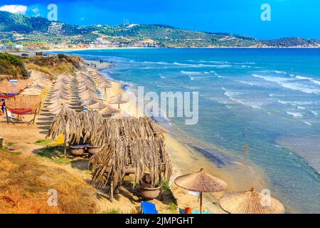 Sarti, Greece beach background with sea waves and umbrellas Stock Photo