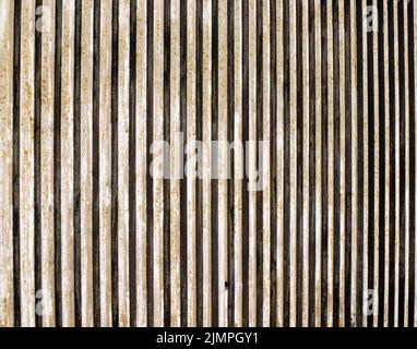 Old textured cast concrete wall with vertical lines and striped design Stock Photo