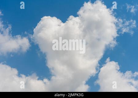 Heart shaped large white cloud on blue sky Stock Photo