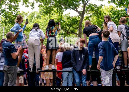 Young People Standing On Railings Along The Mall Take Photos Of The Queen's Birthday Parade, Platinum Jubilee Celebrations, London, UK. Stock Photo