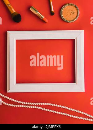 White horizontal art frame, make-up products and pearl jewellery on orange background as flatlay design, artwork print or photo Stock Photo