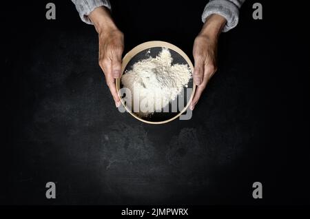 Female hands holding round wooden craft trays with a green resin