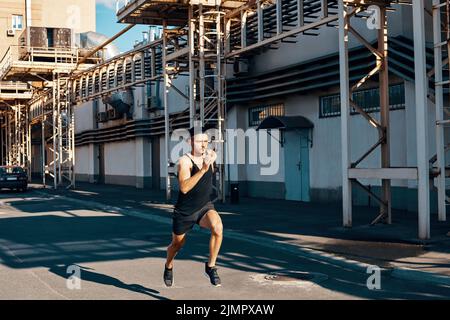 Young man runner running in industrial city background Stock Photo