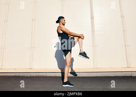 Sporty athlete man doing warm up and stretch legs Stock Photo