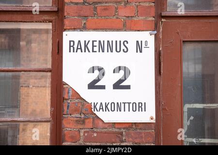 Palkkakonttori. Old broken sign or placard on shipyard office building wall in Munkkisaari district of Helsinki, Finland. Stock Photo